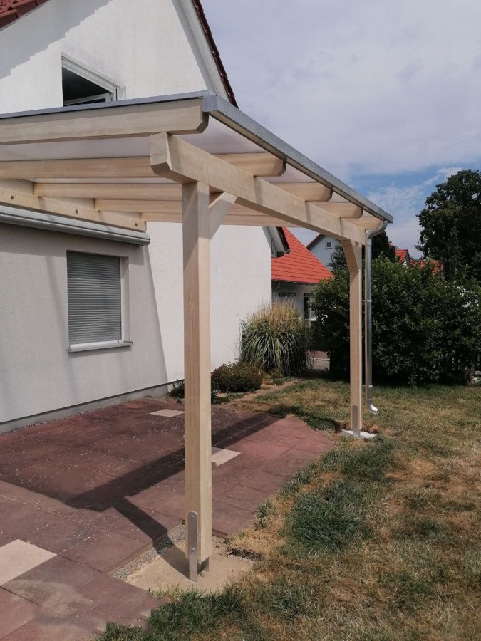 Beranda Terrassenüberdachung aus hellem BSH-Holz mit Stegplatten-Eindeckung an einem Einfamilienhaus