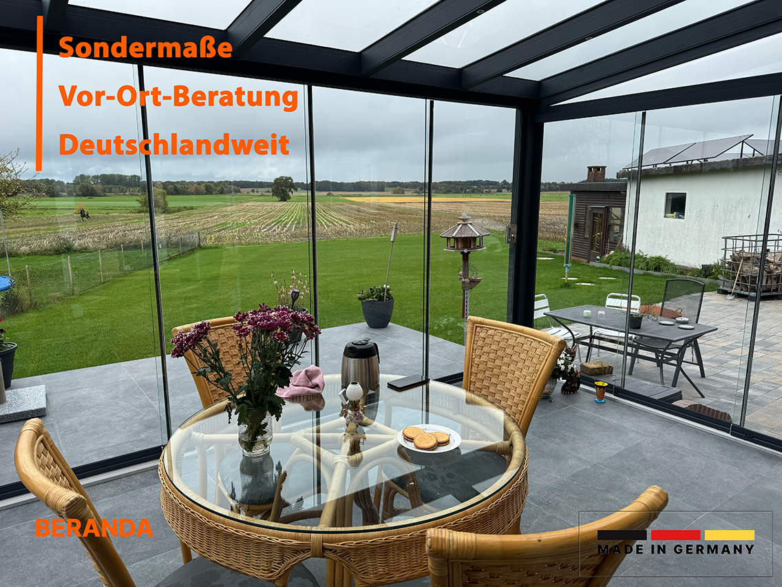 Kunden-Wintergarten mit Glasschiebewänden – gemütliches Gartenzimmer bei Beranda®, Blick auf freies Feld mit Tischgruppe zum Tee genießen